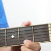Spelar bm-ackordet på en gitarr