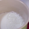 Skumma mjölk för hand för en cappuccino