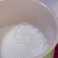 Skumma mjölk för hand för en cappuccino