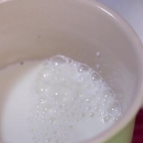 Skumma mjölk för hand för en cappuccino