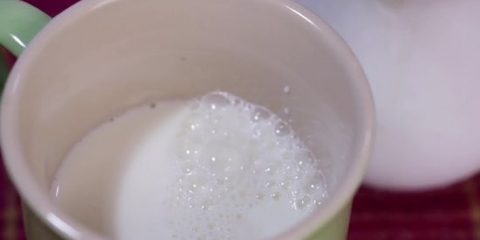 Skumma mjölk för hand för en cappuccino